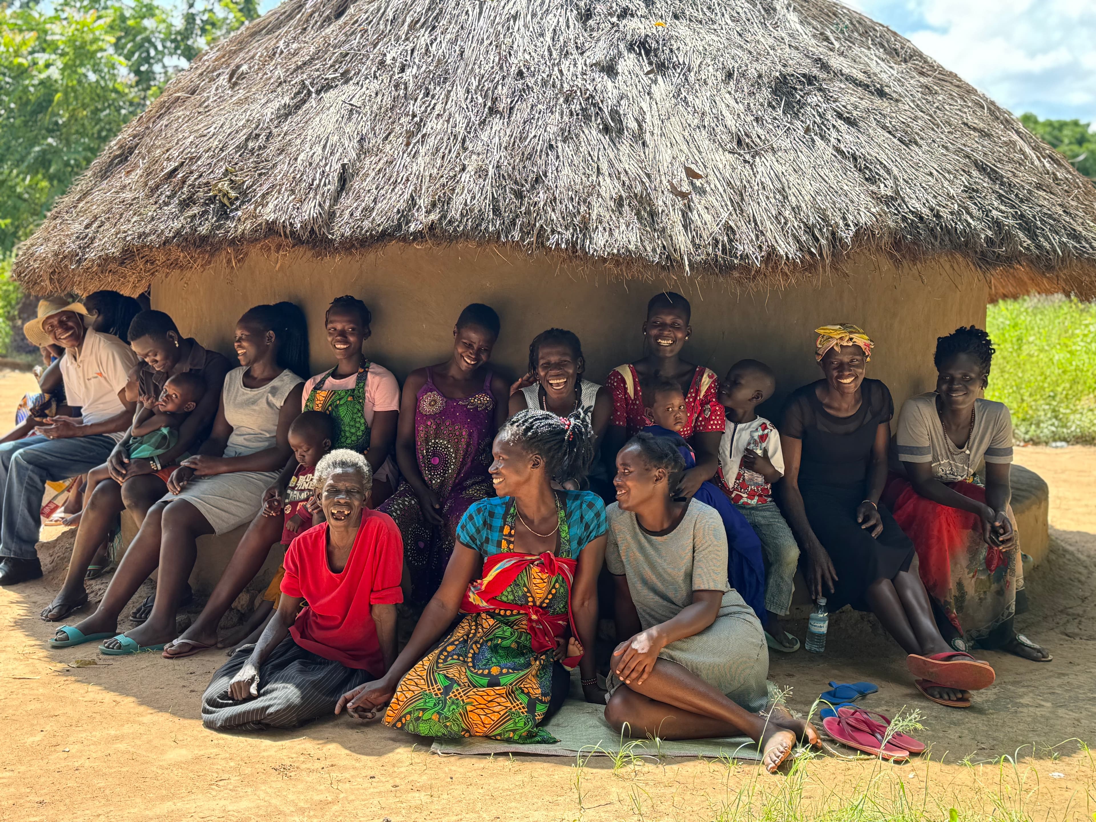 Wide community group photo in front of painted building